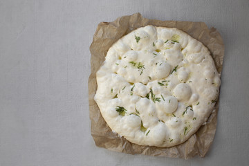 .Dough for focaccia. Raw focaccia with olive oil and rosemary. Natural bread dough. Leaven.