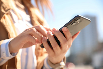 MYKOLAIV, UKRAINE - MARCH 16, 2020: Woman holding iPhone 11 Black outdoors, closeup