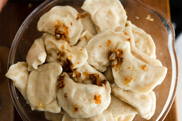 hot food cooked at home in the kitchen,national dish,quick cooking dumplings,full pan of boiled dumplings,pulp-dumplings stand in a transparent bowl on the kitchen table
