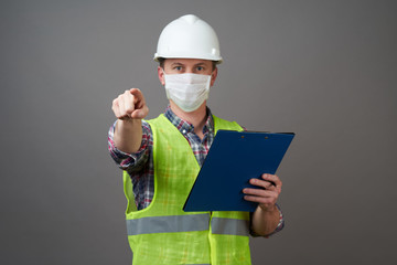 Young engineer worker wear a white helmet and medical mask