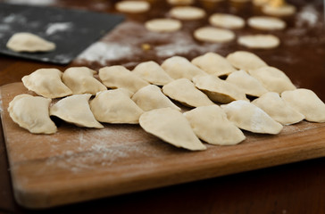 National dish,raw dumplings lie on a wooden board,homemade cooking dumplings with meat,beautifully arranged dumplings