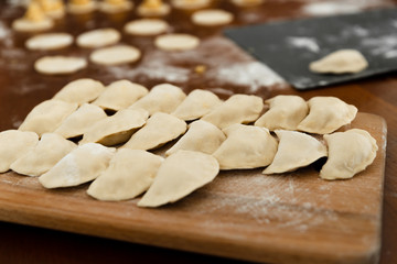 National dish,raw dumplings lie on a wooden board,homemade cooking dumplings with meat,beautifully arranged dumplings