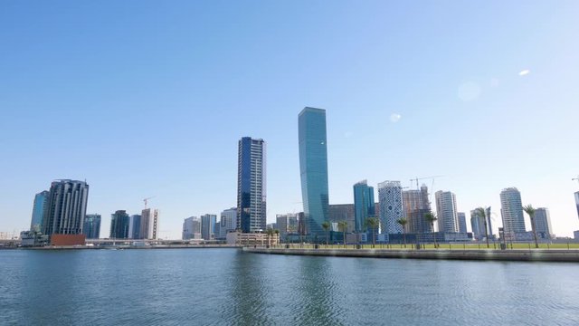 Picturesque view from lake water of park, cityscape and construction of new high rise building