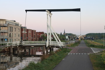 Obraz premium Wooden drawbridge called Witte Brug during sunrise in the town of Nieuwerkerk aan den IJssel over the ring canal of the Zuidplaspolder Nederland