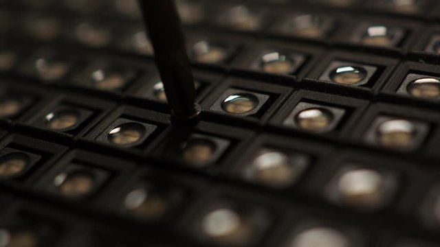 Manually unscrewing screw with hand and screwdriver.