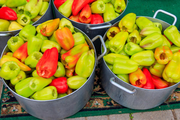 Many peeled bell peppers in large pans. Preparation for canning or cooking