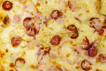 Texture of a delicious fresh pizza with sausage, red onion and cheese