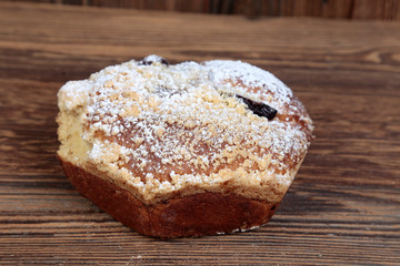 View, close-up of a homemade, fresh, natural cake filled with fruit on a wooden, brown, rustic table.