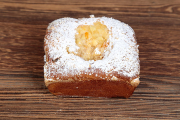 A view, close-up of homemade fresh, mold yeast cake stuffed with fruit, apple mousse on a wooden, brown, rustic table.
