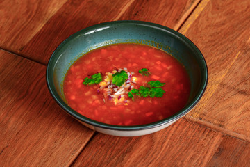Borscht. Red Ukrainian Russian soup in bowl with sour cream and green onion, isolated on wooden background.