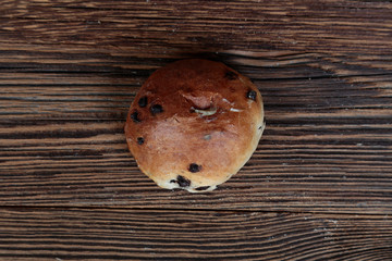 Top view, close-up of a stuffed bread roll on a wooden, brown, rustic table.