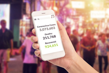 hand holding phone with covid-19 coronavirus pandemic statistic data updated on screen with number of Coronavirus Cases, Deaths and Recovered. covid-19 situation update during of spreading illness