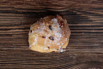 Top view, closeup of a fresh, homemade, stuffed bread roll on a wooden, brown, rustic table.