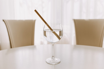 Glass of water with a bamboo straw on a white table. Concept of sustainability and environment care.