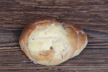 Top view, close-up of a fresh, homemade bun with filling on a wooden, brown, rustic table.