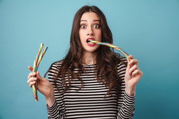 Photo of scared beautiful woman holding and eating candies