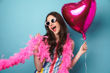 Photo of delighted young woman posing with balloon at camera