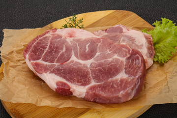 Raw pork steak over wooden board