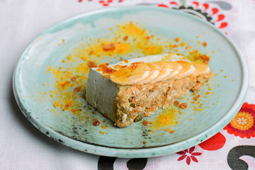 A piece of cream cake with bananas served on a blue plate. Sweet sugary cream dessert. Fruit cake pie.