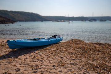 A canoe on a beach on the island of Menorca in Spain. - obrazy, fototapety, plakaty