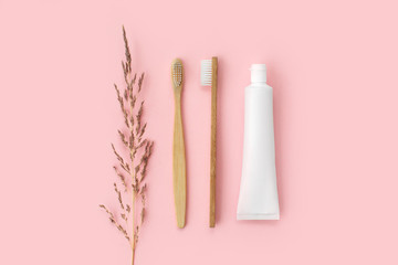 Set of eco-friendly toothbrushes, toothpaste and other tools on pink background. Dental and healthcare concept. Top view, flat lay.