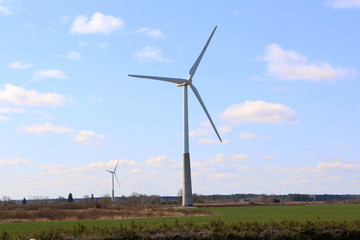 Fototapeta premium A wind turbine rotates against a blue sky.