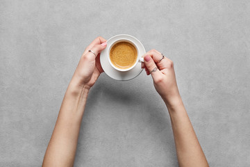 Woman hands holding a coffee viewed from above. Top view. Copy space