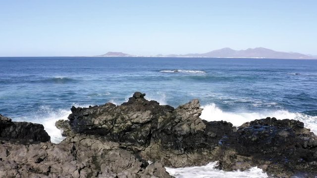 Ocean Waves Splash on Cliffs in Slow Motion at Corralejo Fuerteventura with Aerial Drone