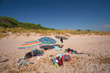 Beach umbrellas and towels, on a beach on the island of Menorca in Spain.
