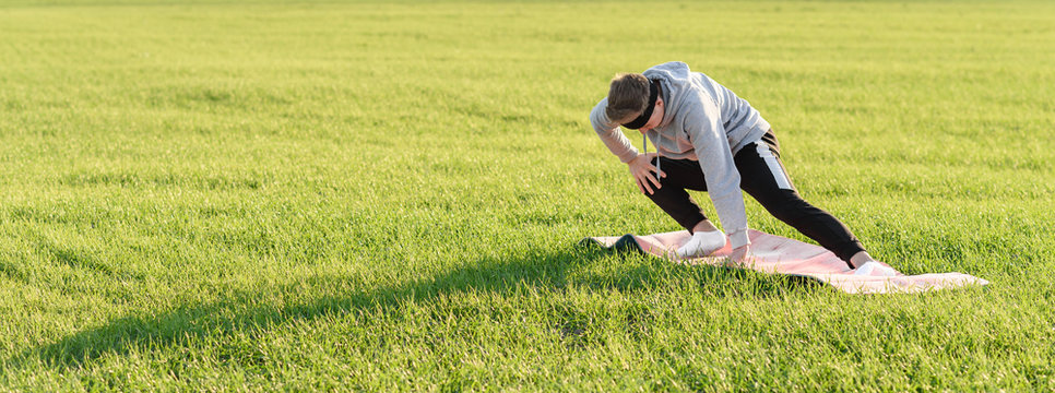 young man doing yoga exercises in the park