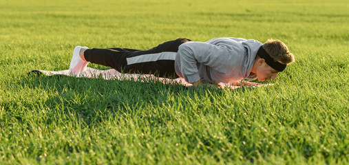 
young man doing exercises in green field