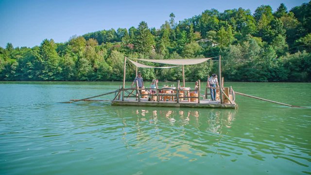 Slow motion shot of a traditional Slovenian raft navigating through Drava river