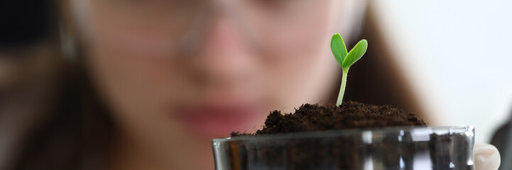 Close-up of scientist hand holding sample of sprout. Green spire growing out from soil. Researcher exploring how germ developing. Botany and ecology concept