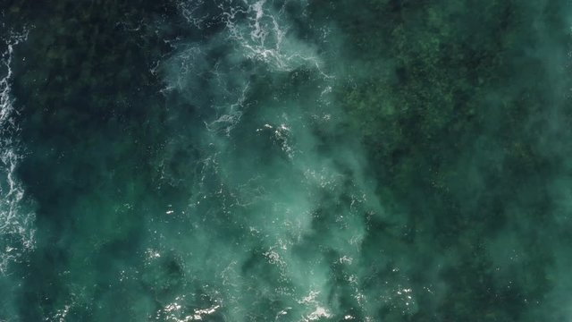 White Ocean Waves flowing over reef in clear Blue Water shot with Aerial Drone