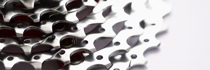 Close-up of metal gearwheel on light background. Detail from bicycle pedal. Device, consisting of...