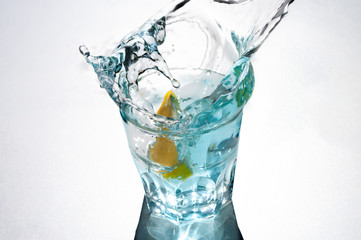 Glass of water splash, lemon inside. Fresh drink.
