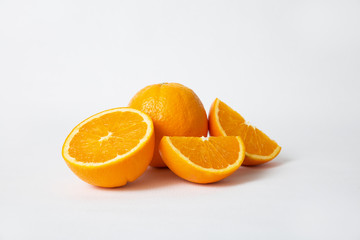 Whole orange fruit and cut slices and half isolated on white background. Closeup shot. Natural vitamin or organic food concept