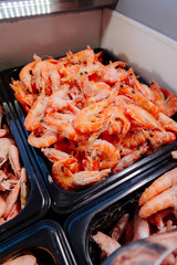 Frozen prawns in a supermarket refrigerated display case. Frozen seafood. Shrimp in the freezer on the window.