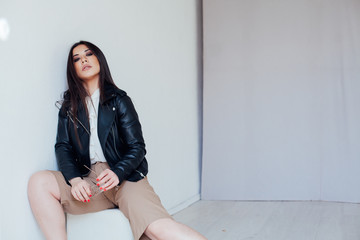 Beautiful fashionable oriental brunette woman in black leather jacket