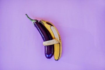 Banana hugs an eggplant with peel.