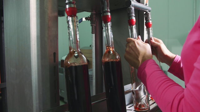 Bottling process of red wine. Special machine equipment bottling red wine while manufacturing