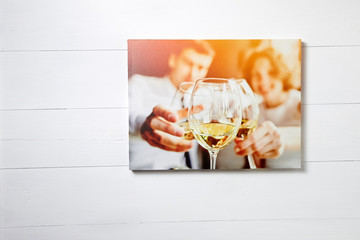 Canvas photo print on white wooden background. Stretched photo on frame