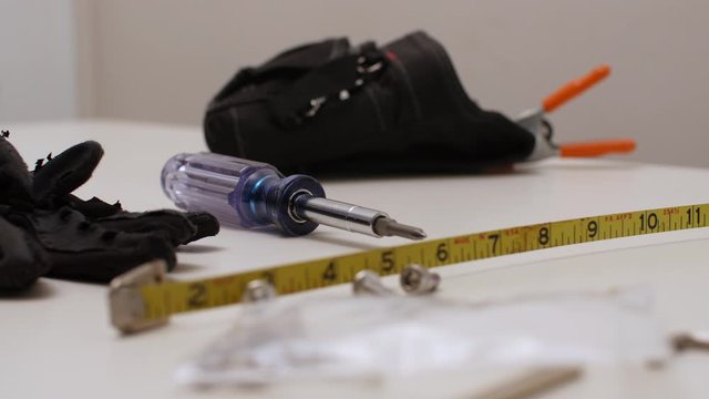 Black man picks up Gaff tape from tools