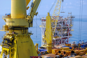 Large work barge carrying new structure module to be installed at oil and gas platform at offshore.