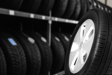 Black car tire in auto store, closeup