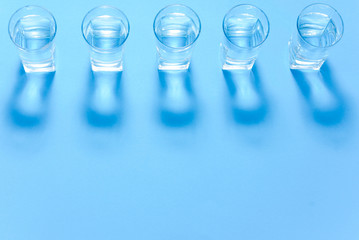 Water filters. Carbon cartridges and glasses on a blue background. Household filtration system.