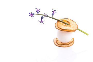 Chicken egg betwin sliced dried pear decorated with purple flower