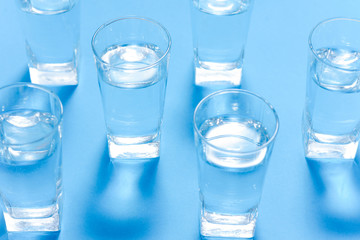 Glasses of water on a paper background. Drawing shadows. Classic Blue color. clean water concept