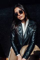 Beautiful fashionable oriental brunette woman in black leather jacket