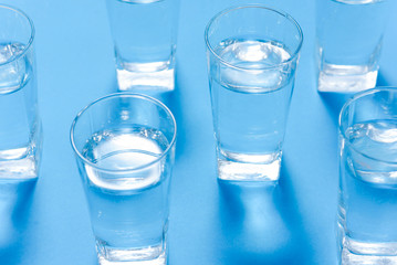Glasses of clean water on color background